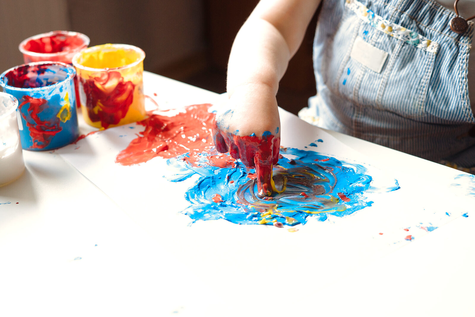 A child exploring colourful paint during an art activity
